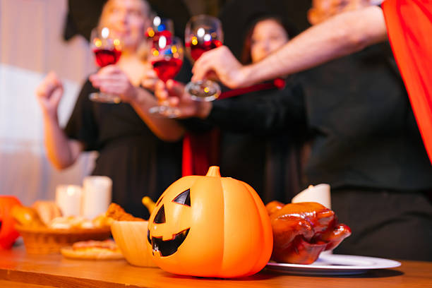 A group of people celebrating Halloween around a decorated table